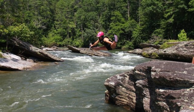 photo of person doing split into the Chattooga River