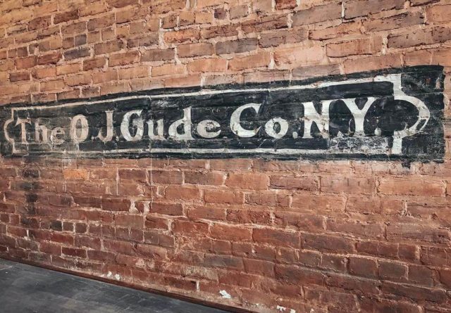 photo of The OJ Gude Co NY painted on brick wall