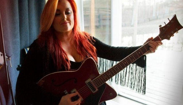photo of Wynonna Judd with a guitar