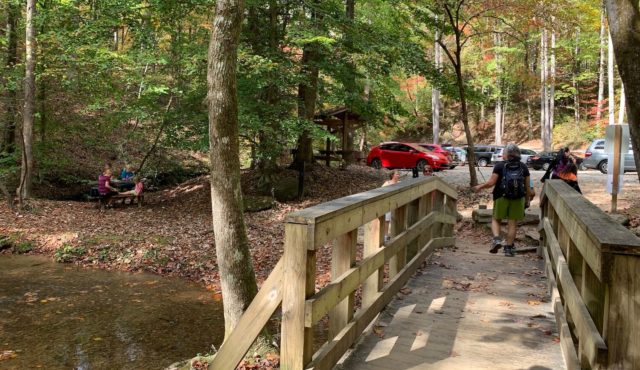 photo of picnic table near creek and parking area