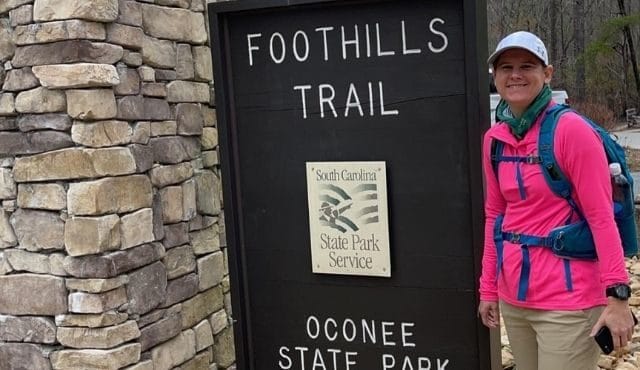 photo of woman next to Foothills Trial sign