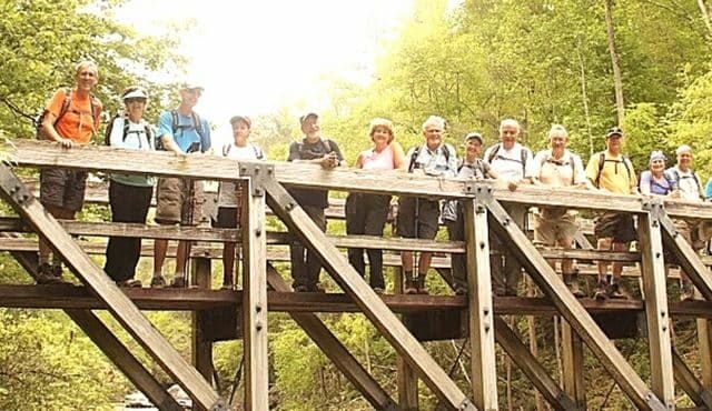 photo of hikers on bridge