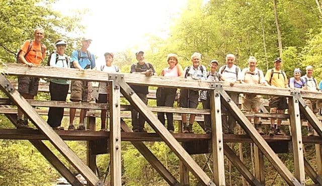 photo of hikers on bridge