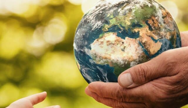 photo of hands and earth