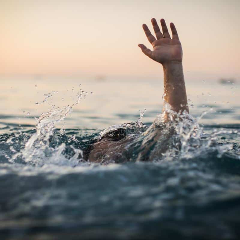 photo of person with hand up in water