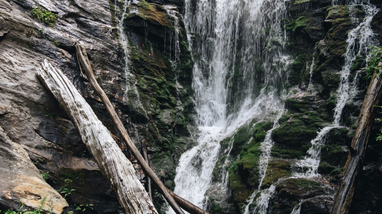 Waterfall cascading over moss-covered rocks in Oconee County, a scenic fall hike location with mountain views.